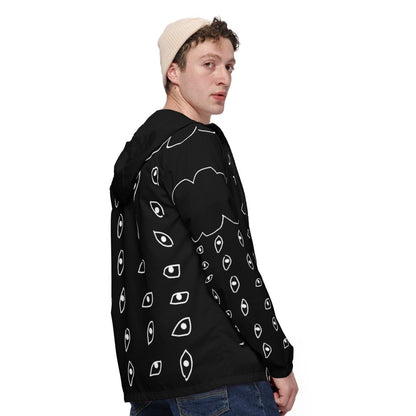 Person wearing a black hoodie with white patterns and blue jeans on a white background