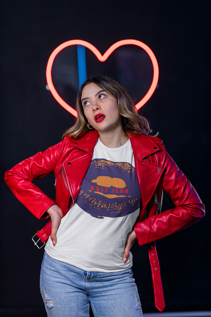 Woman in a red jacket and white t-shirt with a graphic design, standing in front of a neon heart sign.