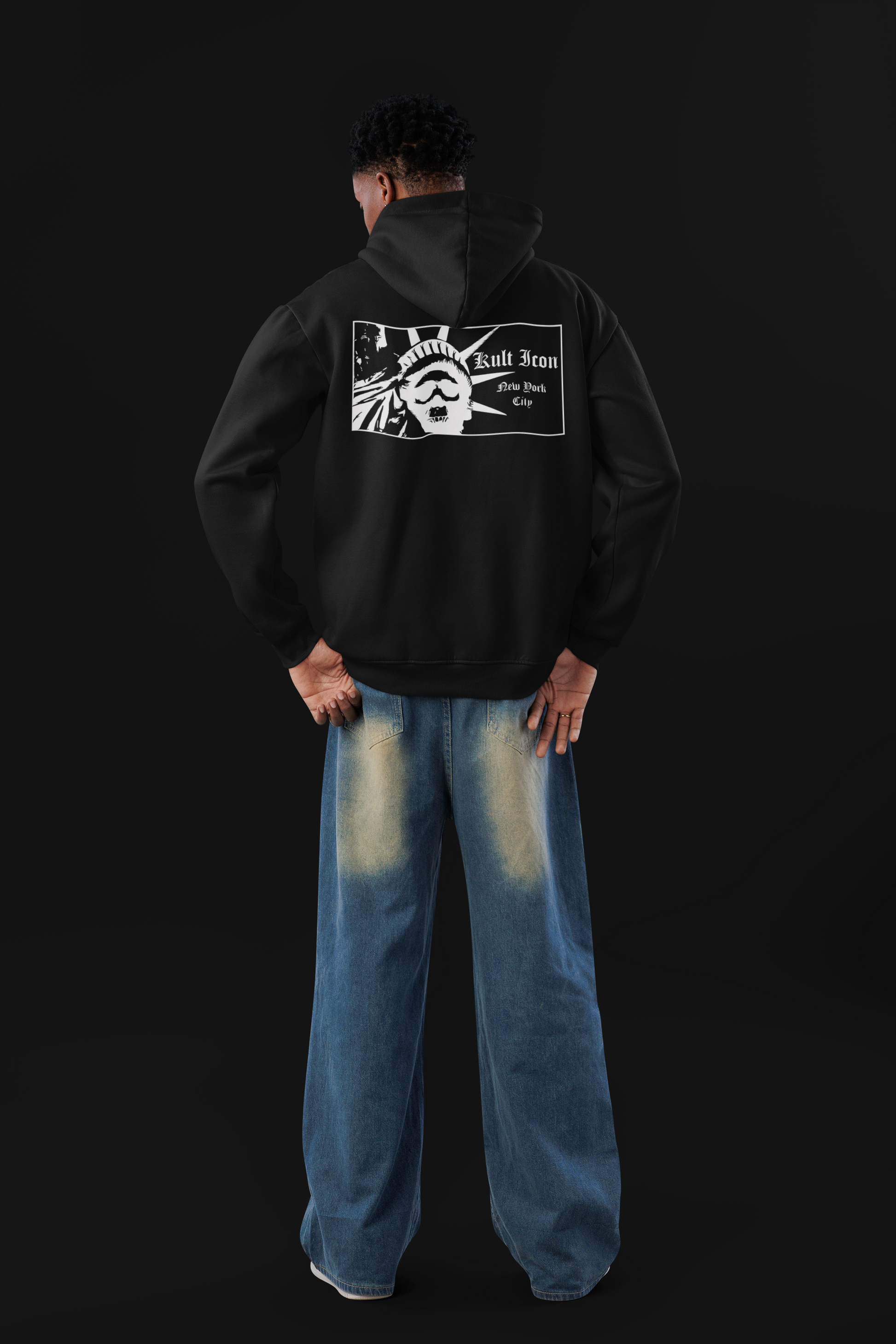 Person wearing a black hoodie with a graphic design on the back against a black background