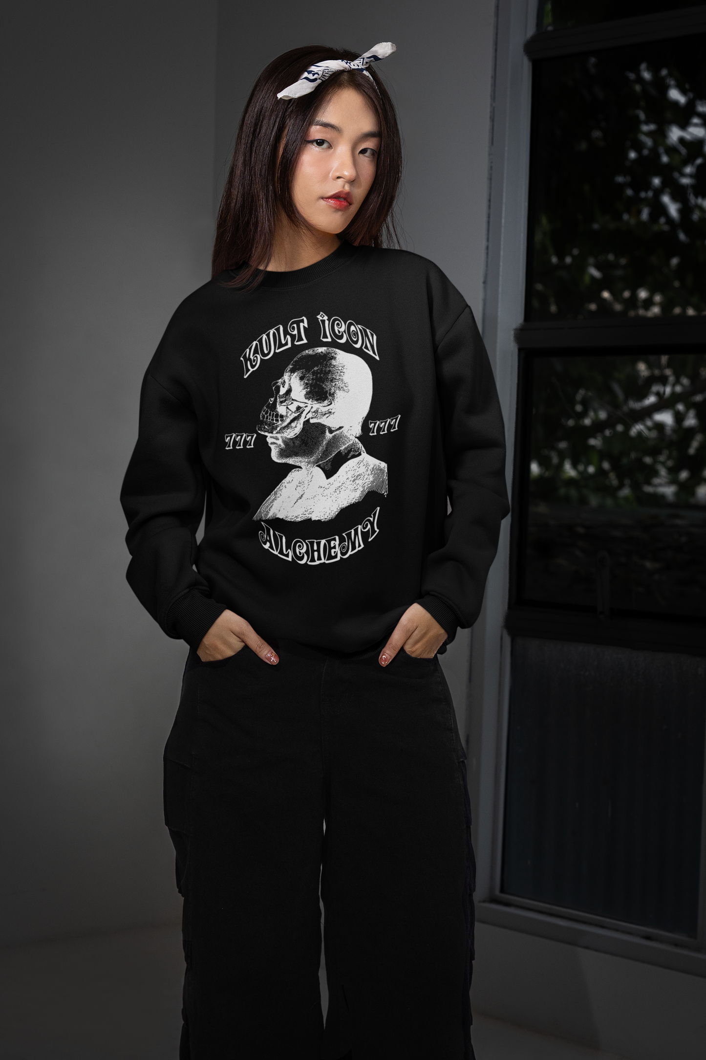 Person wearing a black sweatshirt with a graphic design, standing against a neutral background.