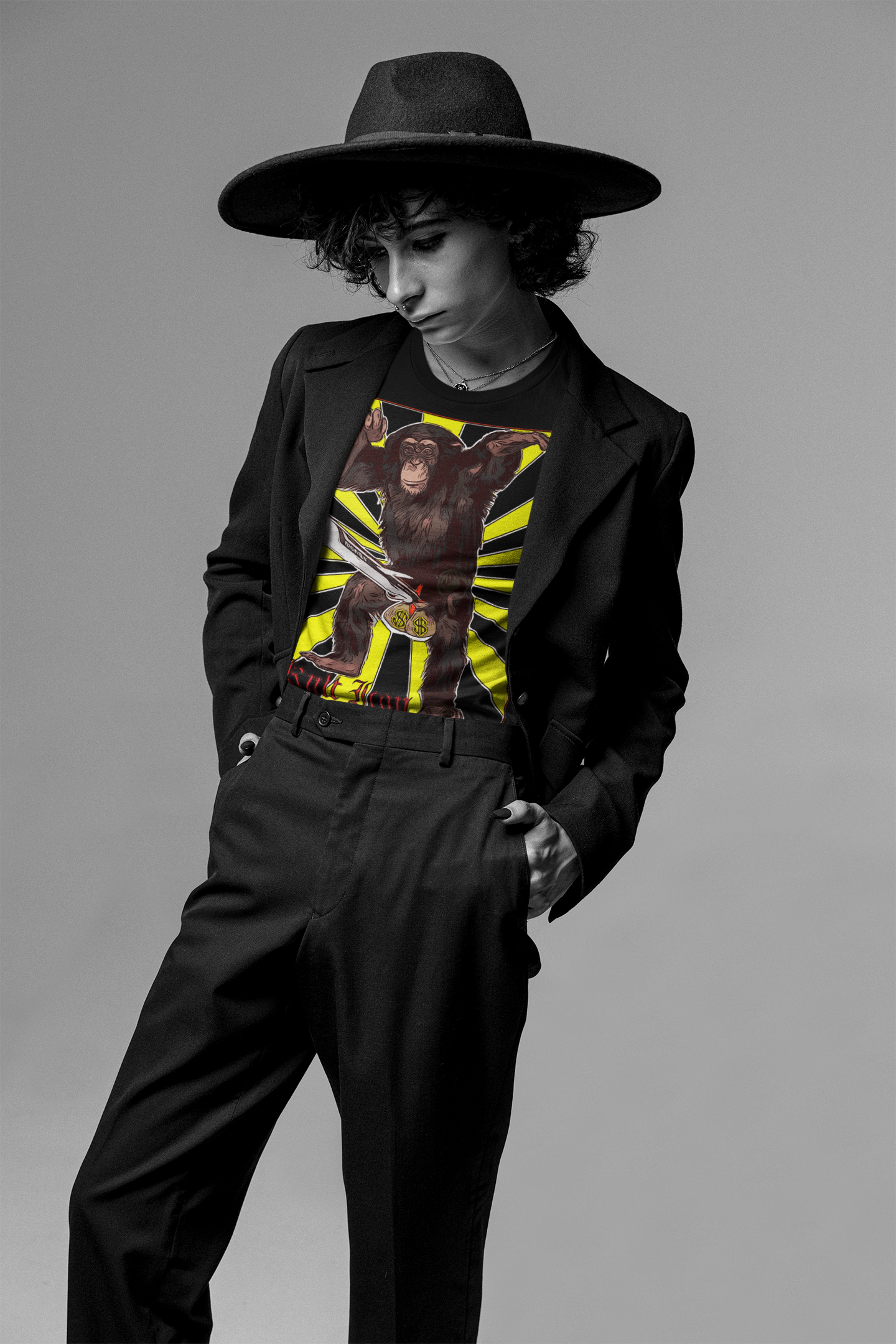 Person wearing a black jacket with a graphic design, black pants, and a wide-brimmed hat on a gray background
