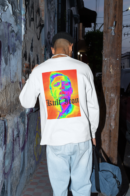Person wearing a white sweatshirt with a colorful graphic design walking past a graffiti-covered wall.