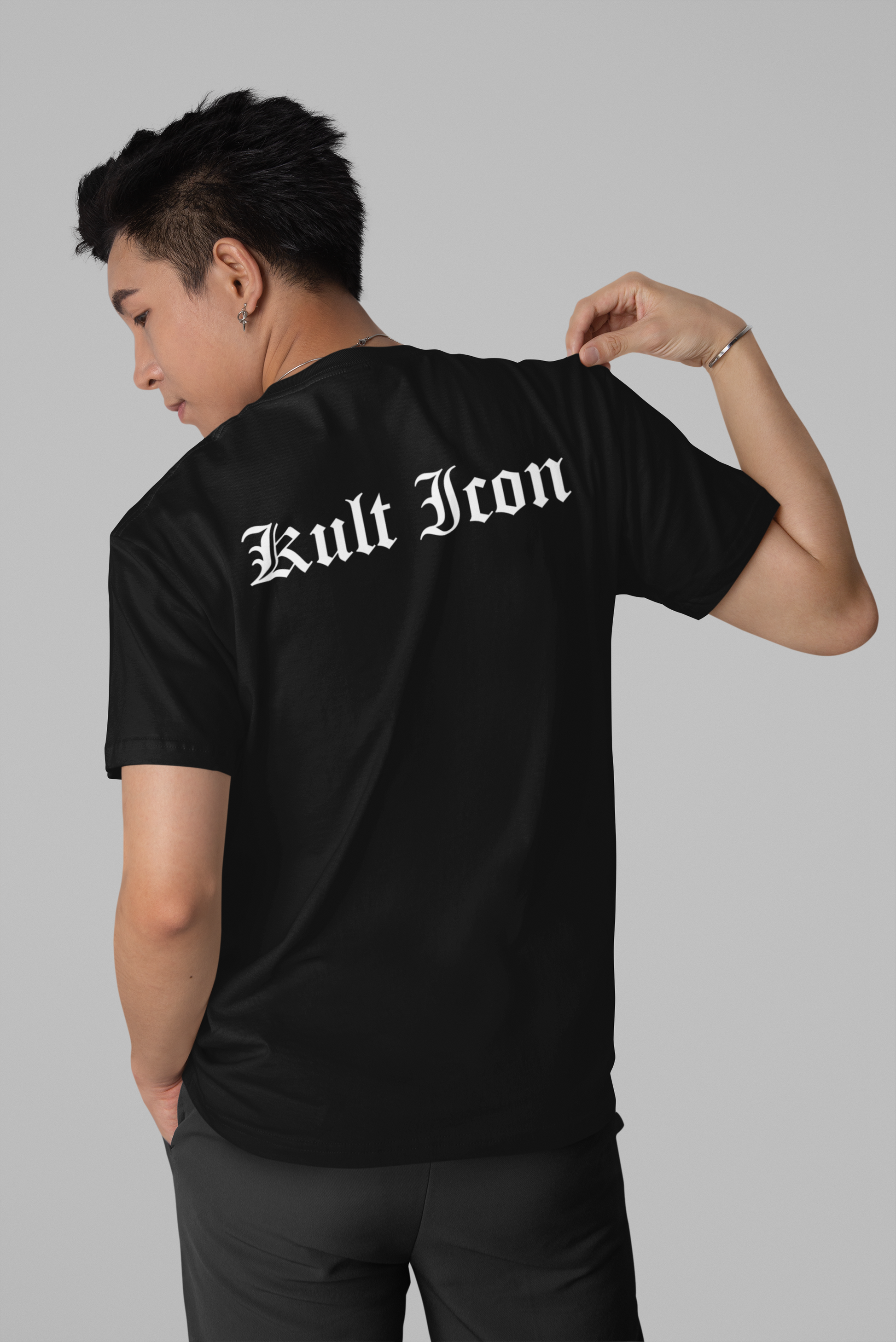 Person wearing a black t-shirt with 'Kult Icon' text on the back against a gray background