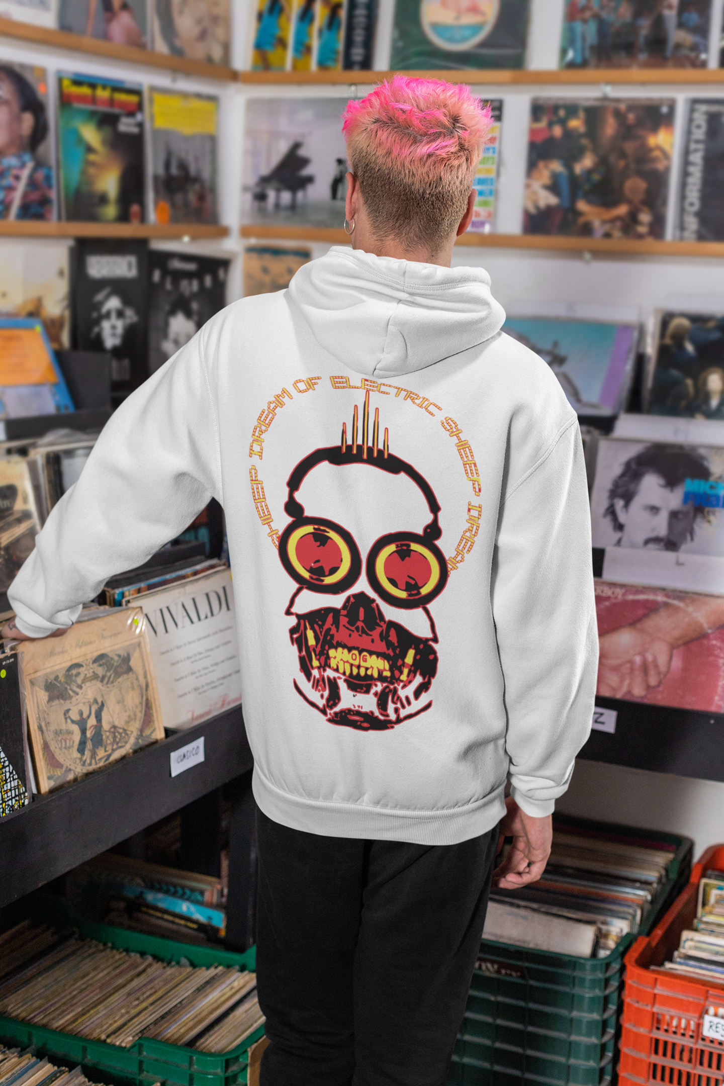 Person wearing a hoodie with a graphic design in a record store