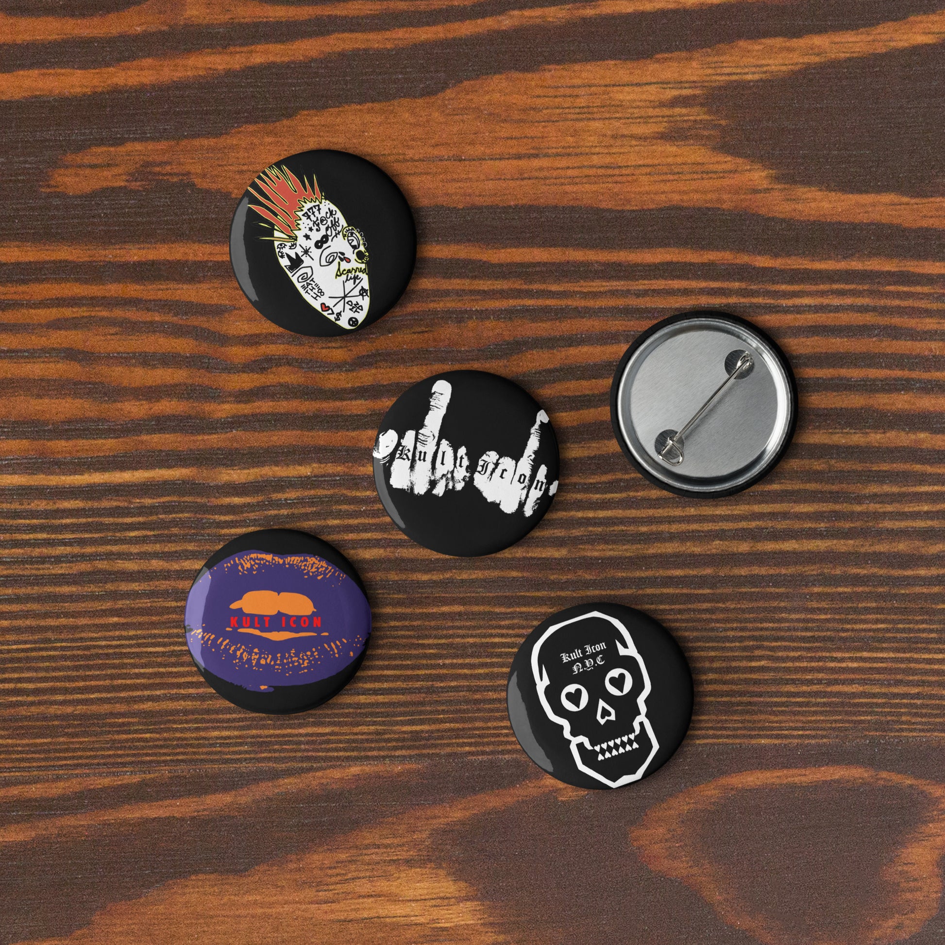 Five buttons with different designs on a wooden surface