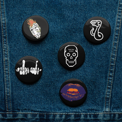 Set of six black buttons with various designs on a denim background