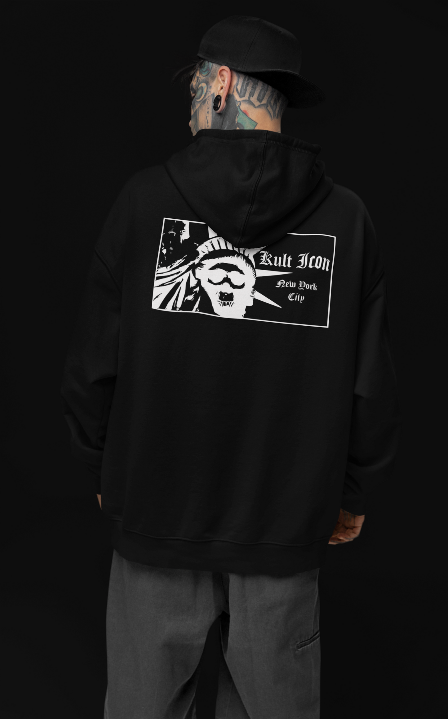 Person wearing a black hoodie with a logo on the back against a black background
