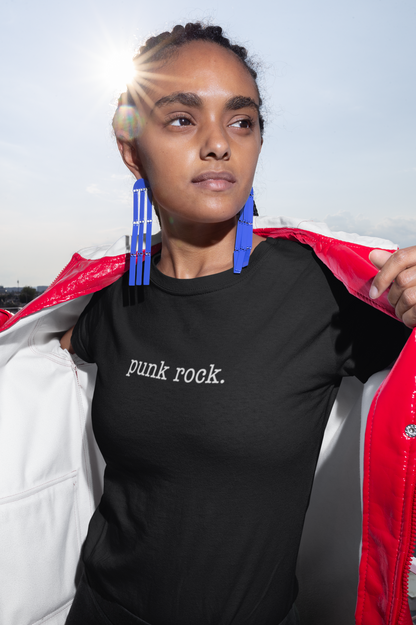 Person wearing a black t-shirt with 'punk rock.' text, holding a red jacket.