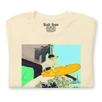 Beige t-shirt with a graphic design of a dog on a surfboard in front of a bridge.