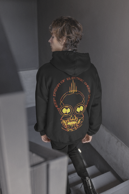 Person wearing a black hoodie with a graphic design on the back, standing in a stairwell.